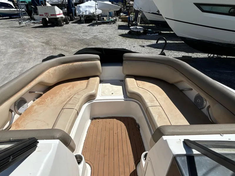 Slide: The Image of 2016 Bayliner 215 Deck Boat interior with spacious seating and wood flooring. - 9
