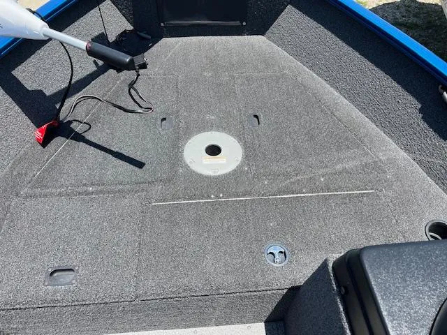 Slide: The Image of 2022 Lund 1650 Angler SS boat interior with gray carpeted deck and fishing rod holder. - 7