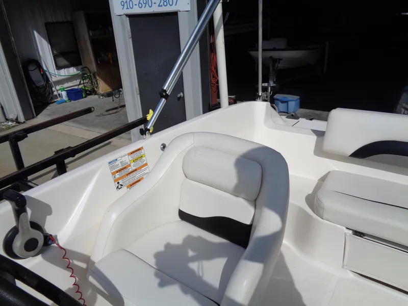 Slide: The Image of 2010 Hurricane FunDeck GS 188 OB boat interior with white seating and steering area. - 15