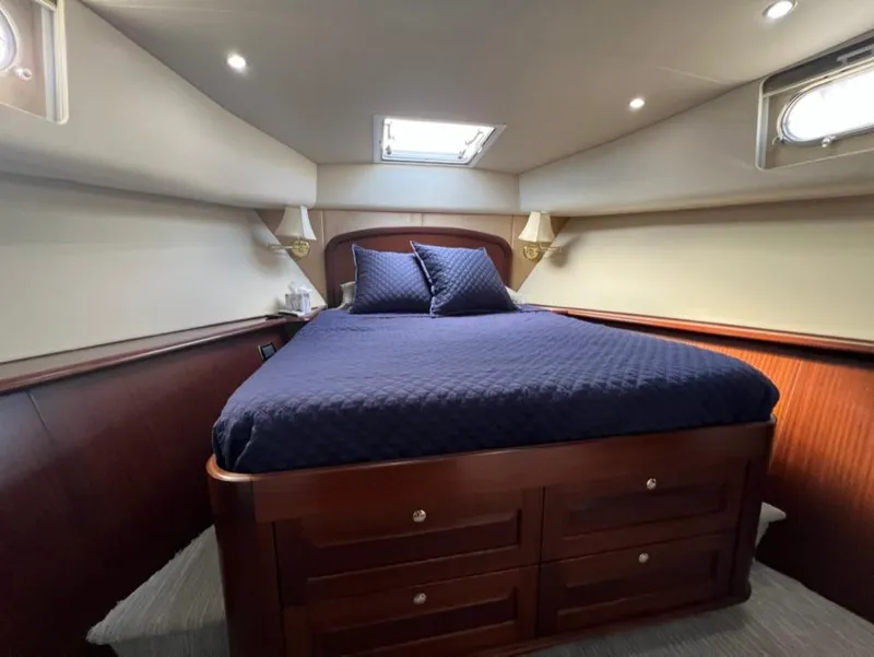 Slide: The Image of Luxurious bedroom in 2005 Pacific Mariner 85 yacht with elegant wood finish and blue bedding. - 28