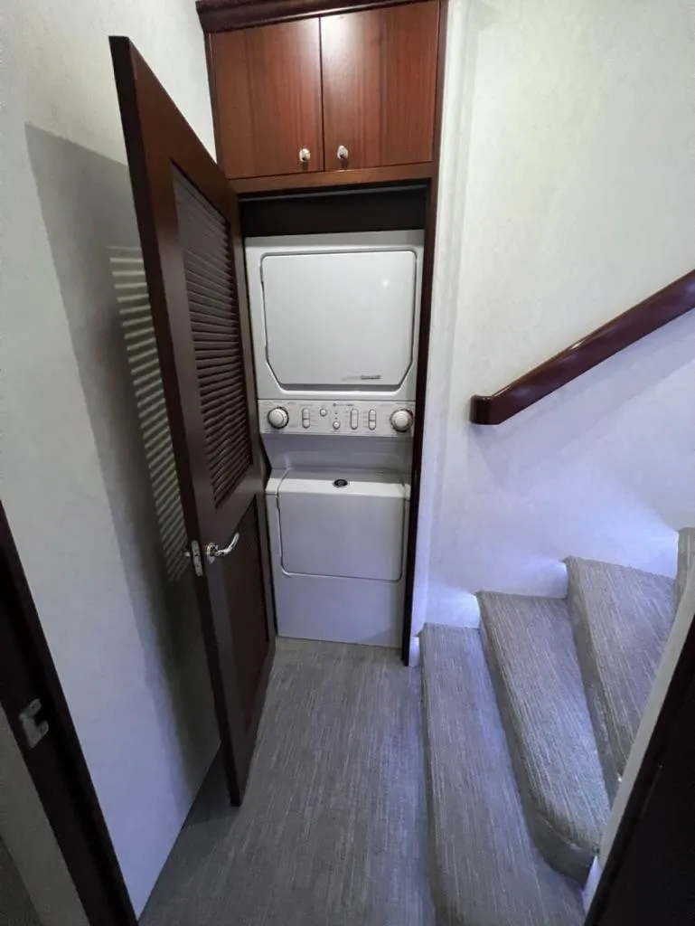 Slide: The Image of 2005 Pacific Mariner 85 yacht interior with stacked washer and dryer near staircase. - 32