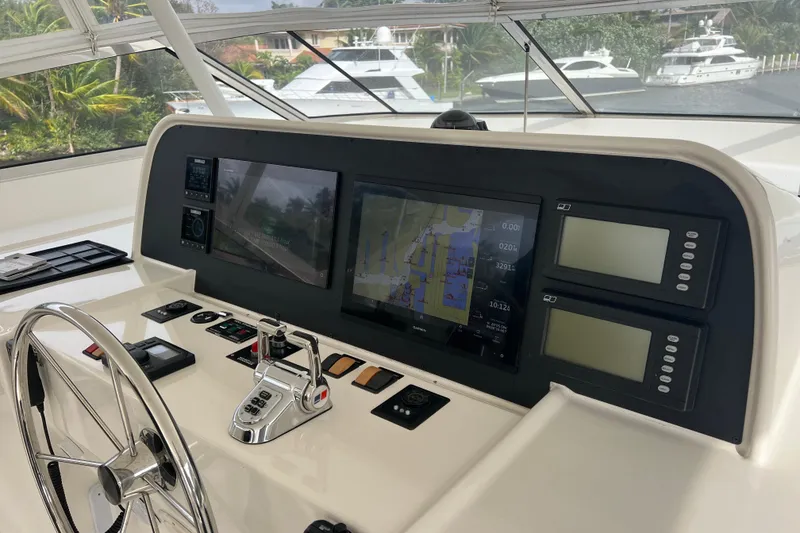 Slide: The Image of Control panel of a 2006 Pacific Mariner 85 yacht with navigation screens and steering wheel. - 42