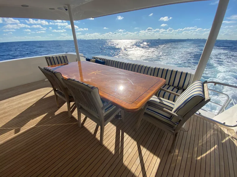 Slide: The Image of Luxury yacht deck with dining table, striped seating, ocean view; Pacific Mariner 85, 2005 model. - 7