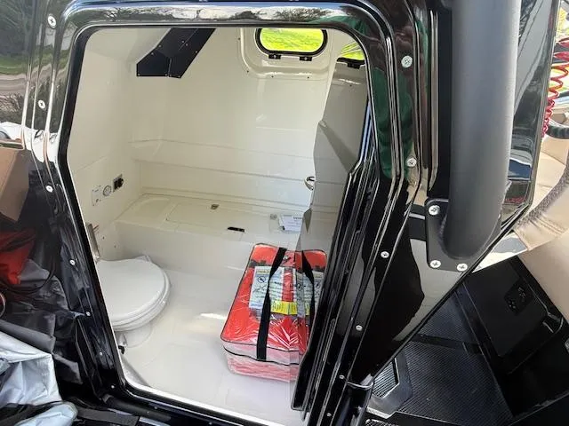 Slide: The Image of Interior of 2025 Brig Eagle 8 boat showing compact cabin with toilet and emergency kit. - 18