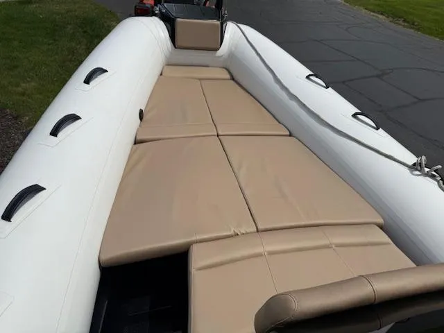Slide: The Image of 2025 Brig Eagle 8 boat with beige seating and white inflatable sides. - 7