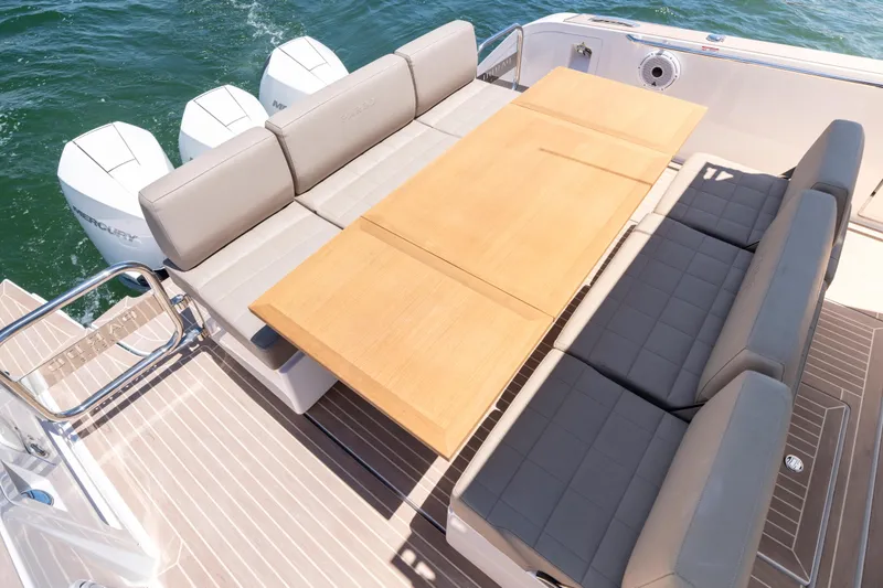 Slide: The Image of Luxury seating area on 2023 Pardo Yachts 38, featuring a wooden table and cushioned benches. - 21
