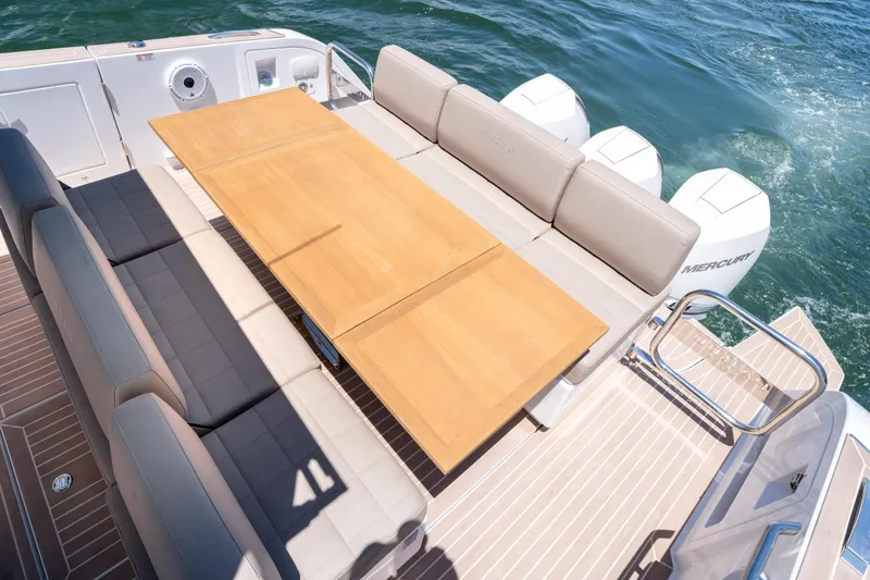 Slide: The Image of Luxury seating area on 2023 Pardo Yachts 38, featuring a wooden table and comfortable cushions. - 25