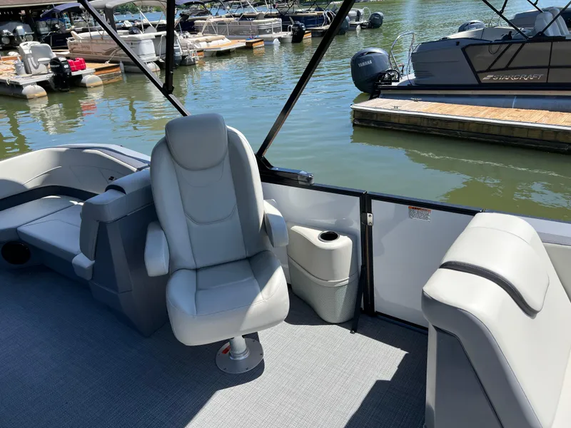 Slide: The Image of 2025 Starcraft GX 22 R DH Sport boat interior with plush seating at a marina. - 11