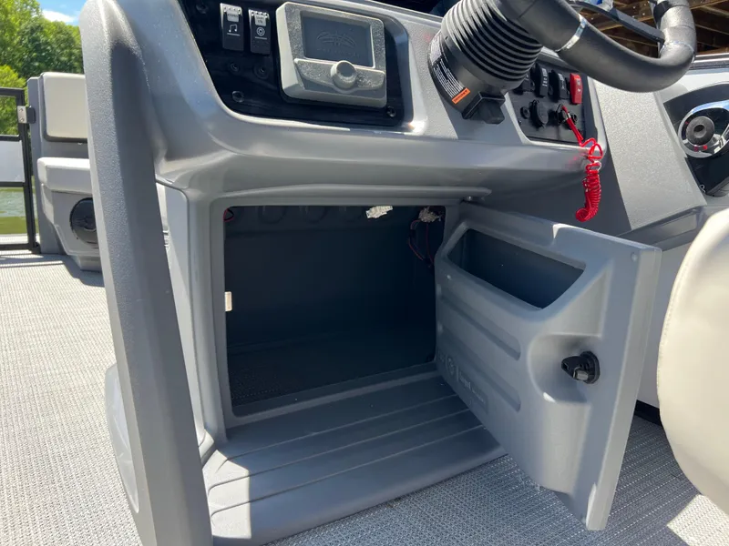 Slide: The Image of 2025 Starcraft GX 22 R DH Sport dashboard with open storage compartment. - 13