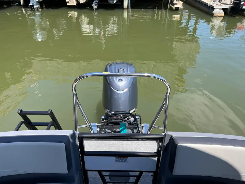 Slide: The Image of 2025 Starcraft GX 22 R DH Sport boat with outboard motor on calm water. - 15