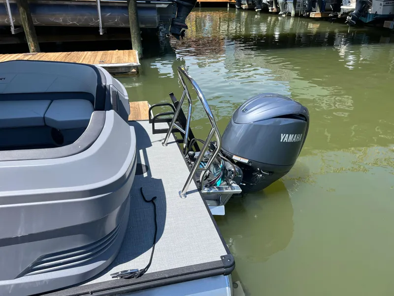 Slide: The Image of 2025 Starcraft GX 22 R DH Sport boat with Yamaha outboard motor docked on calm water. - 2