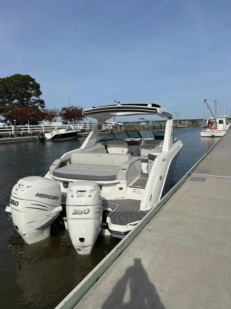 Slide: The Image of 2023 Sea Ray SLX 310 OB boat docked with twin Mercury outboard engines. - 11