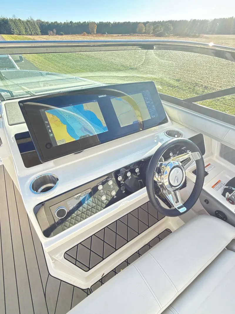 Slide: The Image of 2023 Sea Ray SLX 310 OB boat dashboard with dual navigation screens and modern steering wheel. - 15