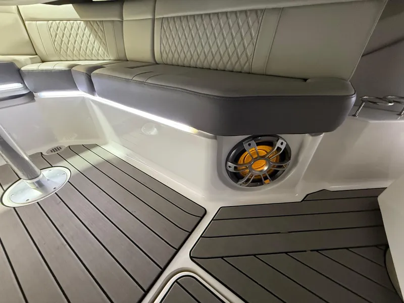 Slide: The Image of 2023 Sea Ray SLX 310 OB interior with cushioned seating and integrated speaker system. - 28