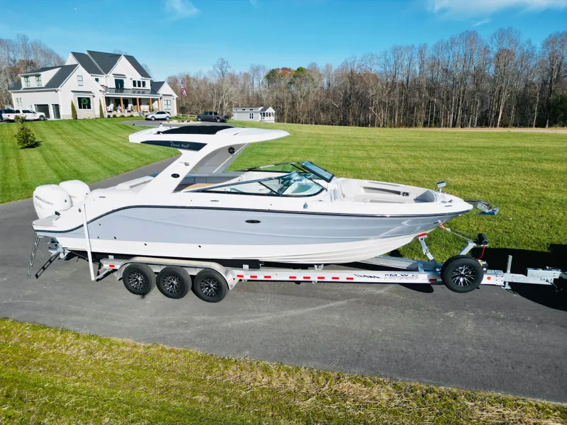 Slide: The Image of 2023 Sea Ray SLX 310 OB boat on trailer, parked on driveway near house. - 3