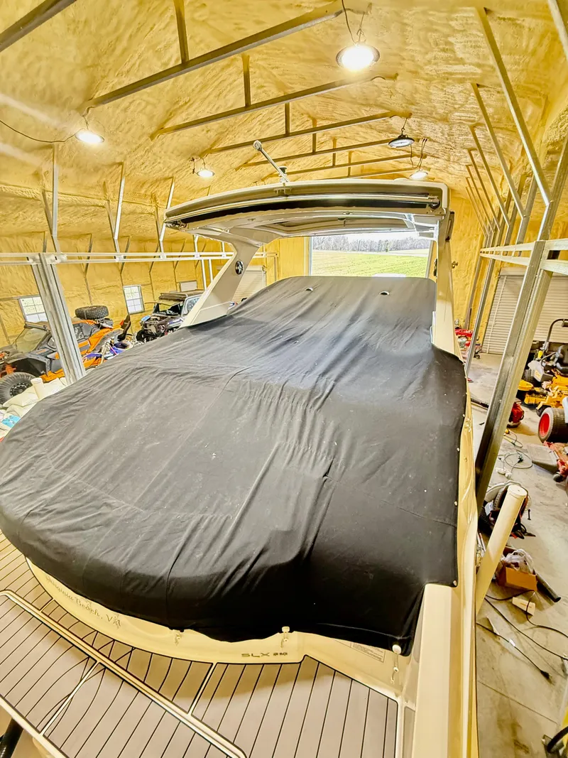 Slide: The Image of 2023 Sea Ray SLX 310 OB boat covered in a storage facility. - 30