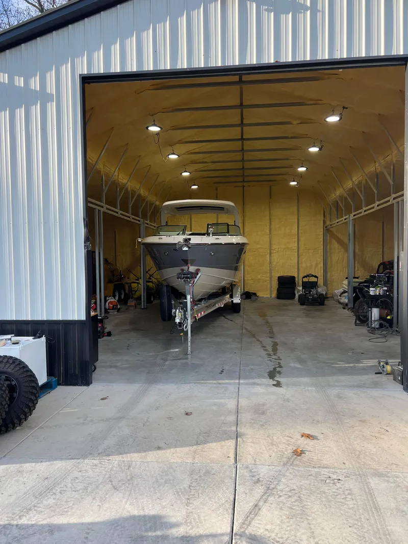 Slide: The Image of 2023 Sea Ray SLX 310 OB boat stored in a spacious garage. - 4