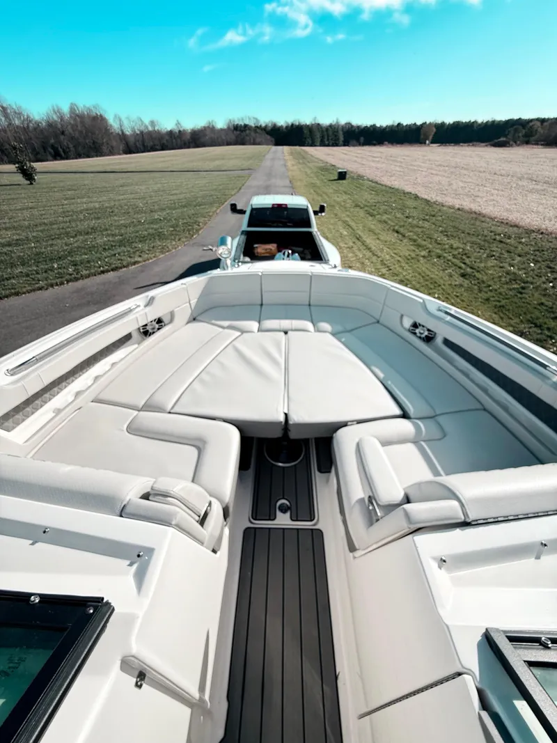 Slide: The Image of 2023 Sea Ray SLX 310 OB boat on trailer, parked on a scenic rural road. - 44