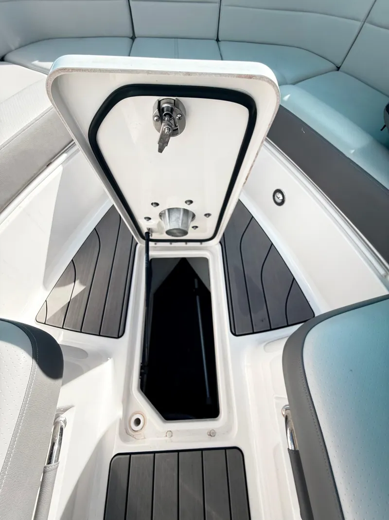 Slide: The Image of 2023 Sea Ray SLX 310 OB boat storage compartment with open hatch, showcasing sleek interior design. - 45