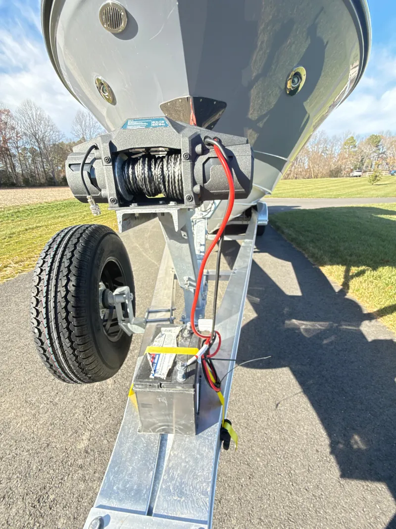 Slide: The Image of 2023 Sea Ray SLX 310 OB boat trailer with winch and wheel on a sunny day. - 46