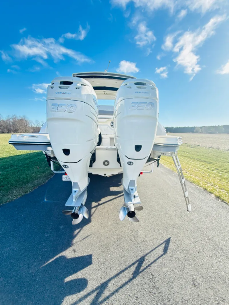 Slide: The Image of 2023 Sea Ray SLX 310 OB boat with dual outboard engines on a sunny day. - 5