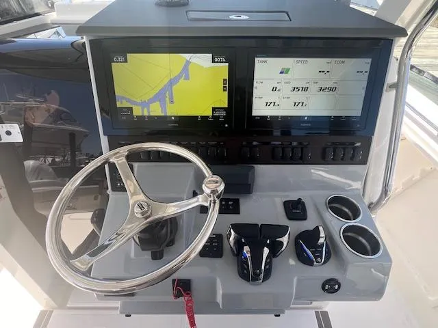 Slide: The Image of 2023 Pursuit S358 boat dashboard with dual screens and steering wheel. - 12