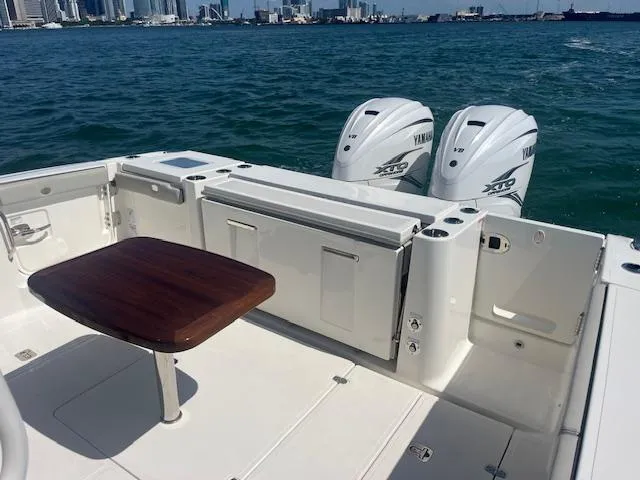 Slide: The Image of 2023 Pursuit S358 boat with Yamaha engines, featuring a wooden table and ocean backdrop. - 13