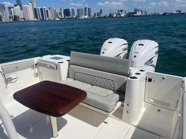 Slide: The Image of 2023 Pursuit S358 boat with seating and table, city skyline in background. - 14