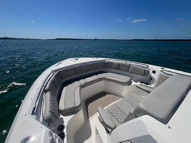 Slide: The Image of 2023 Pursuit S358 boat with luxurious seating on open water under clear blue sky. - 16