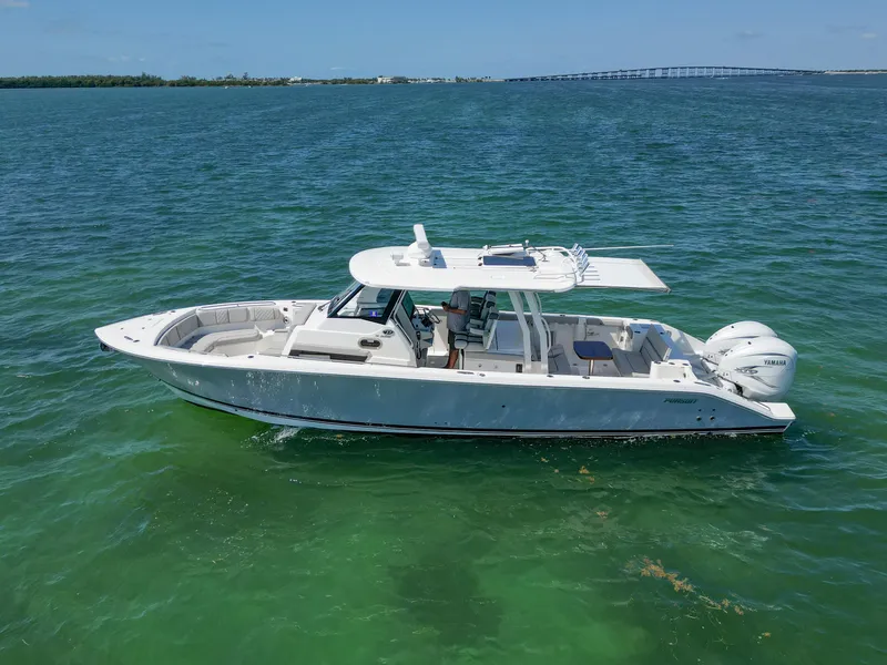 Slide: The Image of 2023 Pursuit S358 boat on clear blue water, showcasing sleek design and powerful engines. - 3