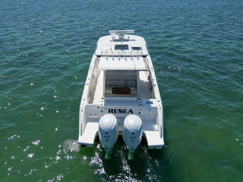Slide: The Image of 2023 Pursuit S358 boat on clear blue water, rear view with twin engines. - 6