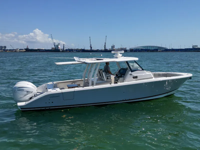 Slide: The Image of 2023 Pursuit S358 boat cruising on calm waters under a clear blue sky. - 8