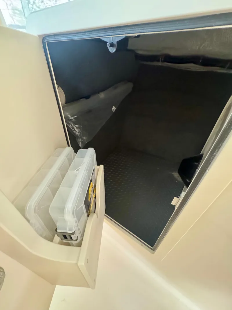 Slide: The Image of Storage compartment inside 2025 Grady-White Freedom 285 boat, featuring organized shelves. - 10