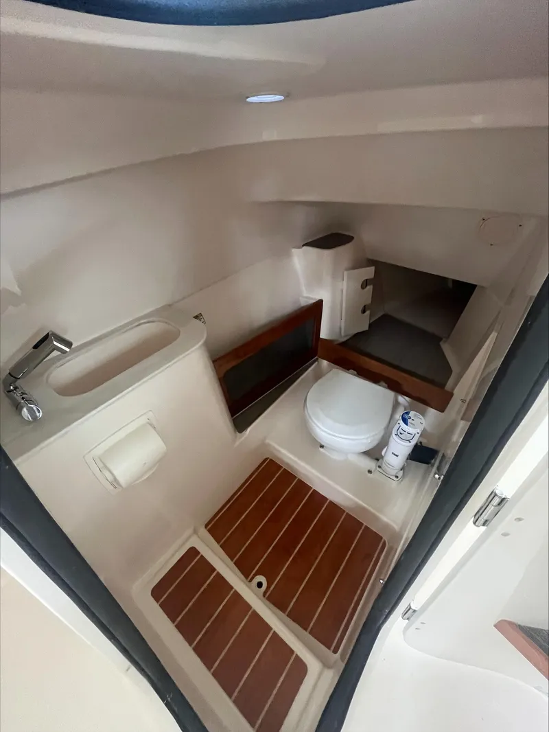 Slide: The Image of 2025 Grady-White Freedom 285 boat interior with sink, toilet, and wooden flooring. - 13