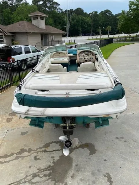 Slide: The Image of 1995 Sea Ray 200 Signature boat with white and green interior, parked on concrete. - 3