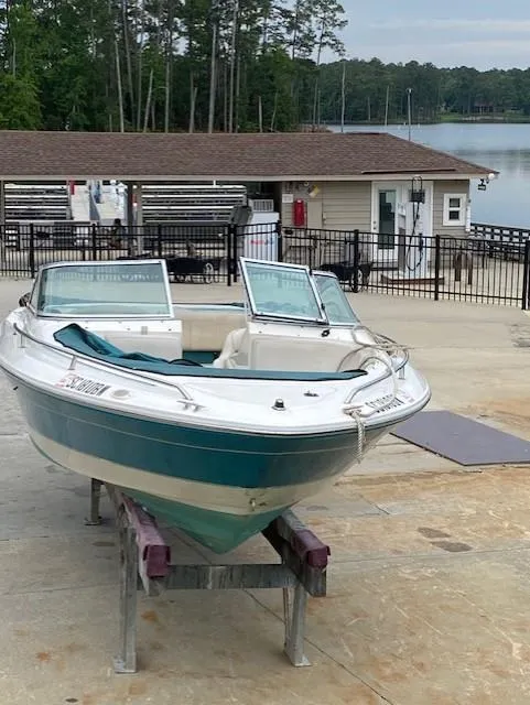 Slide: The Image of 1995 Sea Ray 200 Signature boat on dock, surrounded by trees and a lake. - 4