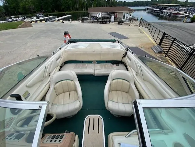 Slide: The Image of 1995 Sea Ray 200 Signature boat with white seating, docked near a marina. - 7