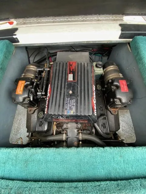Slide: The Image of 1995 Sea Ray 200 Signature engine compartment with MerCruiser motor, surrounded by teal upholstery. - 8