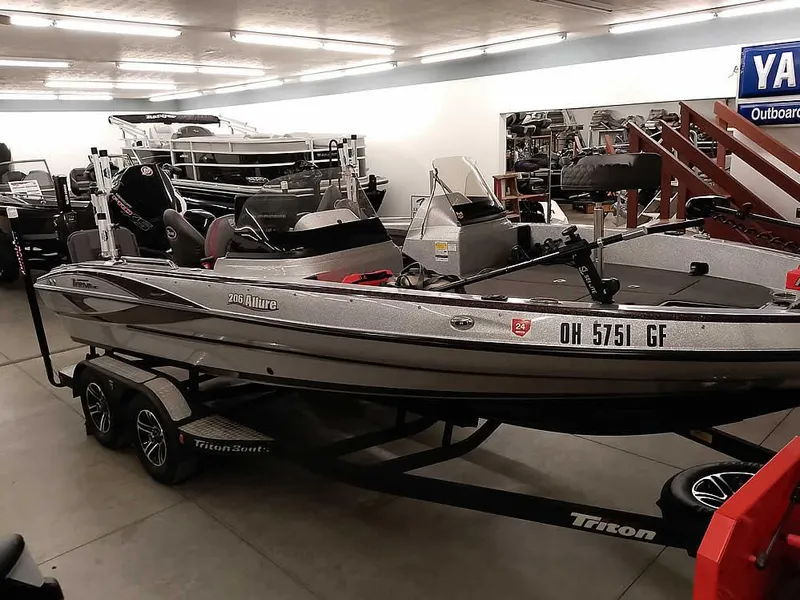 Slide: The Image of 2021 Triton 206 Allure boat displayed indoors on a trailer. - 1