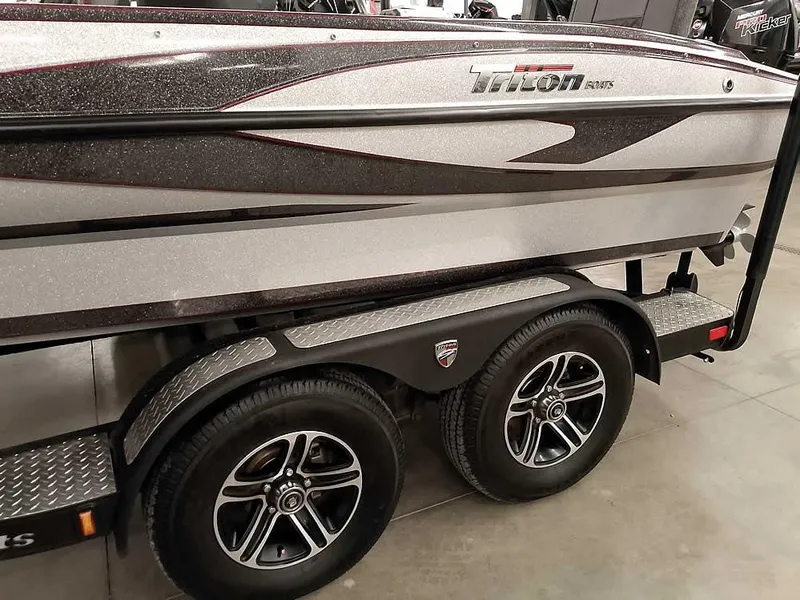 Slide: The Image of 2021 Triton 206 Allure boat on trailer, featuring sleek design and dual wheels. - 12