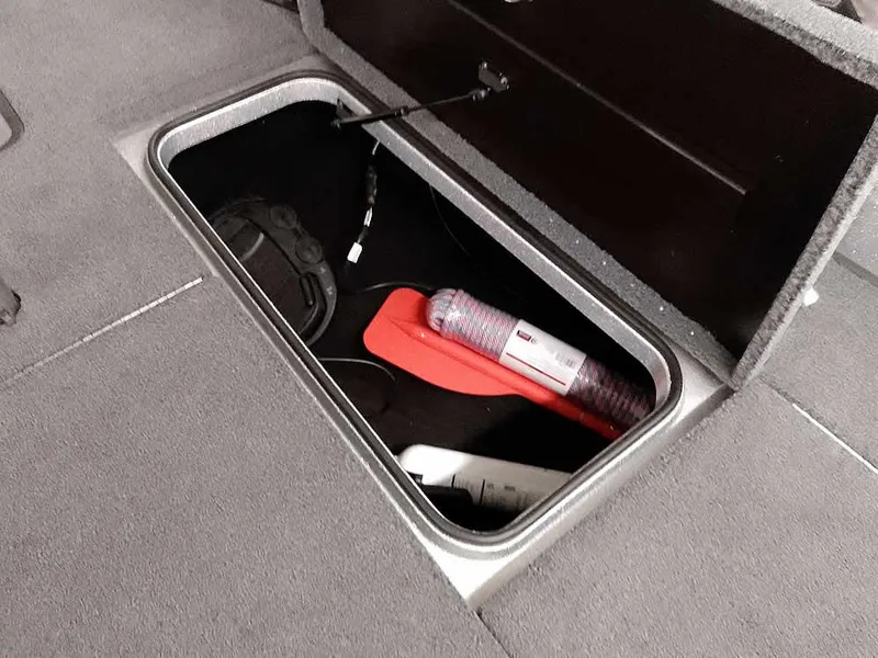 Slide: The Image of Storage compartment in 2021 Triton 206 Allure boat with various items inside. - 18