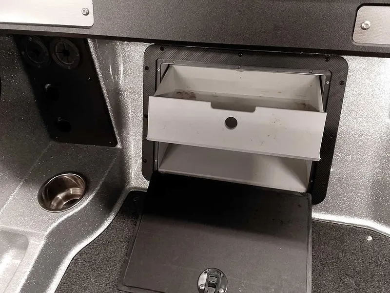 Slide: The Image of 2021 Triton 206 Allure boat storage compartment with cup holder and utility panel. - 27