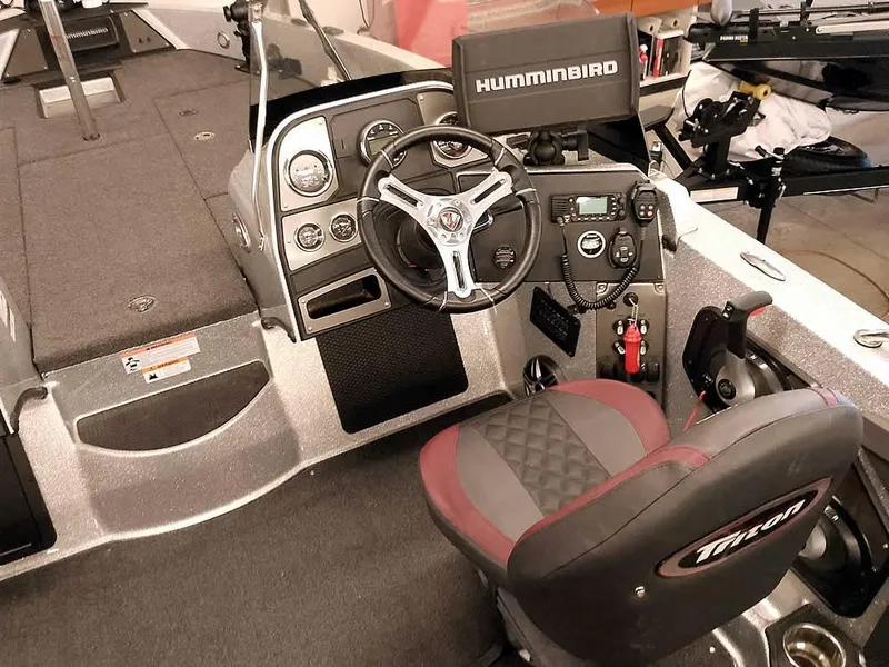 Slide: The Image of 2021 Triton 206 Allure boat cockpit with steering wheel and Humminbird electronics. - 29
