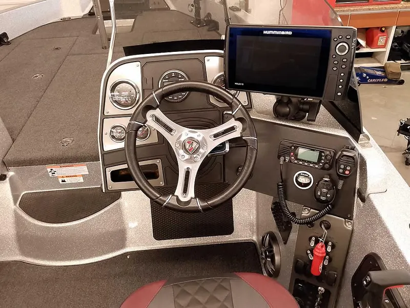 Slide: The Image of 2021 Triton 206 Allure boat dashboard with steering wheel and electronic controls. - 30