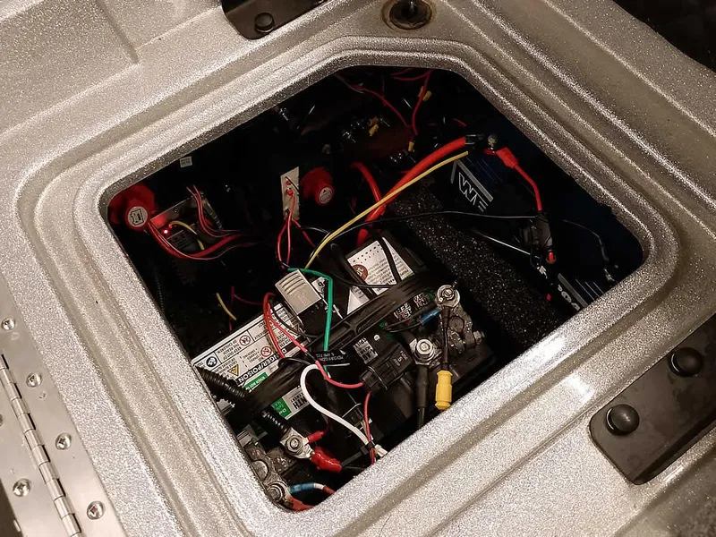 Slide: The Image of 2021 Triton 206 Allure boat battery compartment with wiring and components. - 45