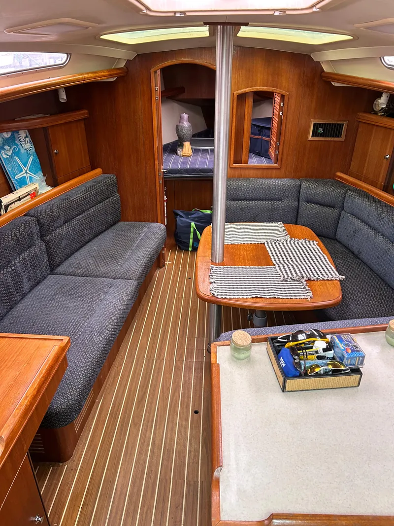 Slide: The Image of Interior of a 2006 Hunter 36 sailboat with cozy seating and wooden finishes. - 10