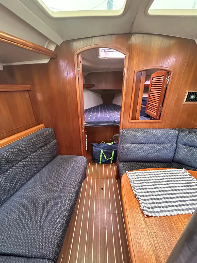 Slide: The Image of Interior of 2006 Hunter 36 sailboat with wood finish and cozy seating area. - 7