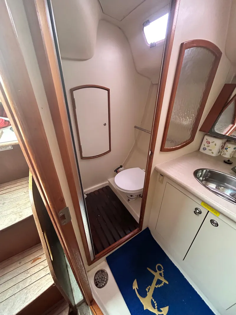 Slide: The Image of 2006 Hunter 36 yacht bathroom with toilet, sink, and anchor-themed mat. - 8