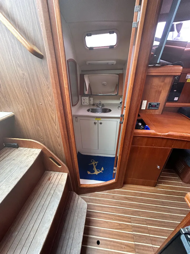 Slide: The Image of Interior of 2006 Hunter 36 sailboat showing compact bathroom and wooden stairs. - 9