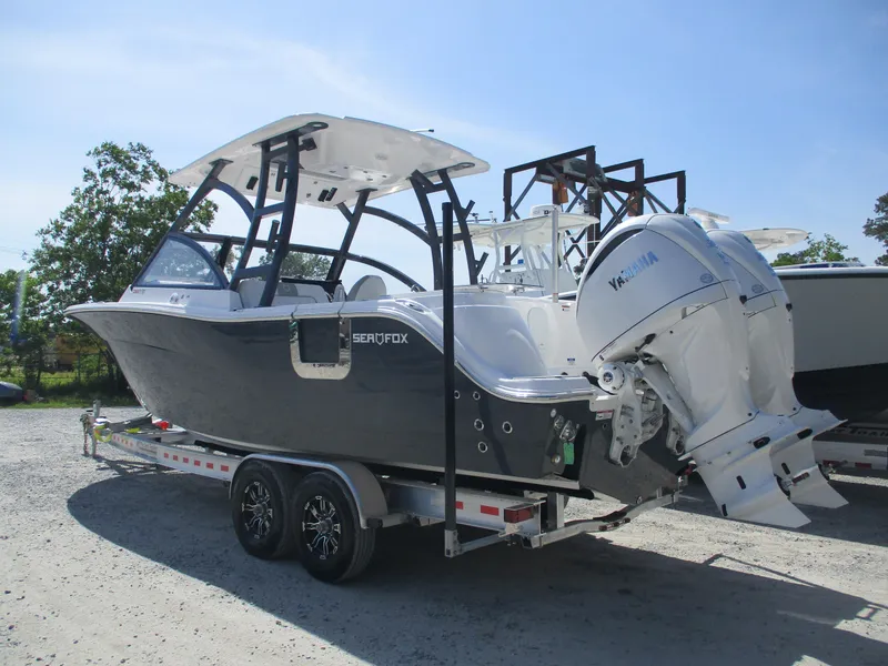 Slide: The Image of 2025 Sea Fox 288 Traveler boat on trailer with dual engines, parked outdoors. - 3